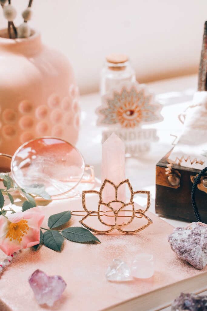 crystals and flowers on table pink background and table