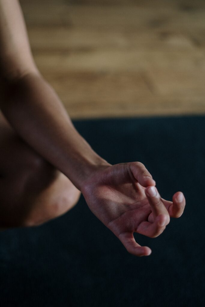 A person's hand extended into a meditative mudra