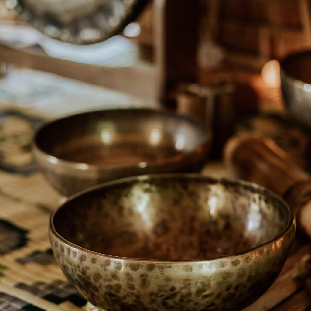 Two golden singing bowls on a table top.